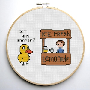 Pode incluir: Um desenho de bordado de ponto cruz com um pato amarelo que pergunta "Got any grapes?" e uma barraca de limonada com uma pessoa atrás do balcão. A barraca tem uma placa que diz "Ice Fresh Lemonade".