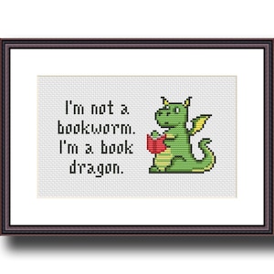 May include: A green dragon with yellow wings is holding a red book and reading. The text says "I'm not a bookworm. I'm a book dragon."