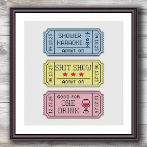 Może przedstawiać: Oprawiona sztuka haftu krzyżykowego z trzema kolorowymi biletami. Górny bilet jest niebieski i głosi "SHOWER KARAOKE". Środkowy bilet jest żółty i mówi "SHIT SHOW". Dolny bilet jest różowy i mówi "GOOD FOR ONE DRINK".