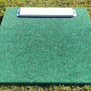 May include: A green artificial turf pitching mound with a white rectangular pitching plate attached to the top.