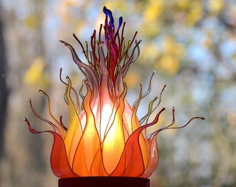 Lámpara de mesa de resina en forma de llama de color naranja, amarillo y rojo.