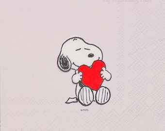 May include: A white napkin featuring a cartoon Snoopy character holding a red heart. Snoopy is white with black ears and markings. The text "My Daydreaming Heart" is written in cursive on the napkin.