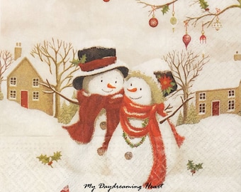 Puede incluir: Dos muñecos de nieve con bufandas y sombreros rojos se encuentran en una escena invernal nevada con casas y árboles. El texto "My Daydreaming Heart" está escrito en la parte inferior de la imagen.