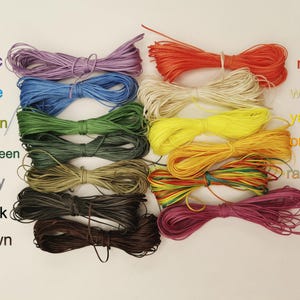 K&ouml;nnte beinhalten: Sortiment von 12 Spulen gewachster Baumwollschnur in verschiedenen Farben, darunter Lila, Blau, Gr&uuml;n, Dunkelgr&uuml;n, Grau, Schwarz, Braun, Rot, Wei&szlig;, Gelb, Orange und Regenbogen.