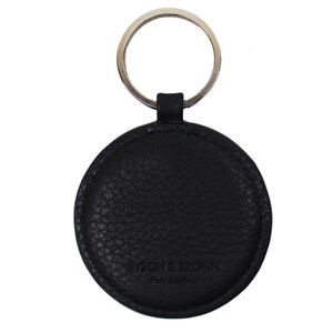 May include: Black leather key chain with a round tag that says "BYRON BARROW Fine Leather".