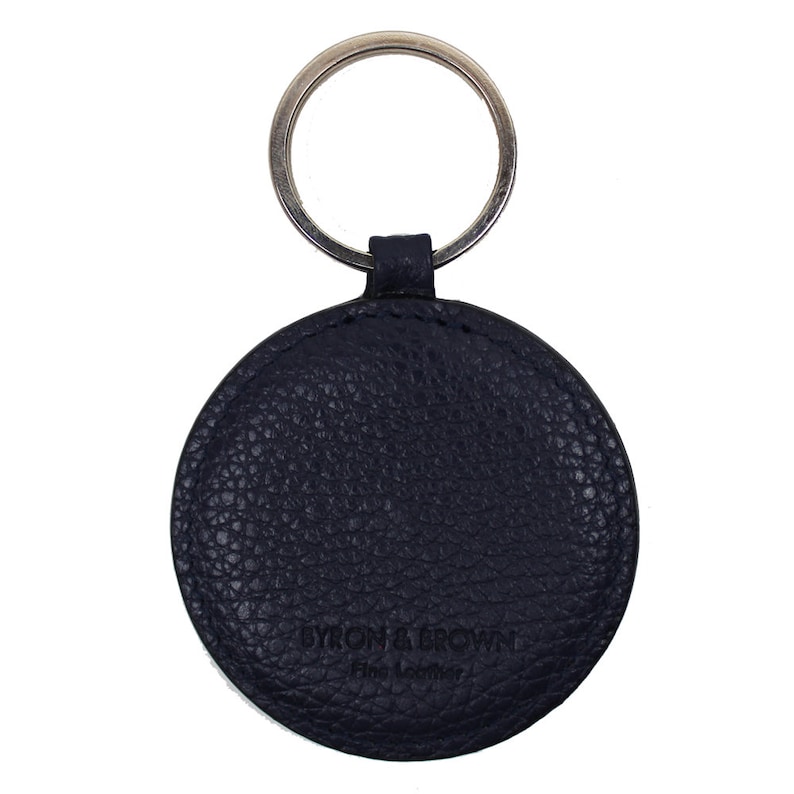 May include: A navy blue leather keychain with a round tag that says "Byron & Brown Fine Leather".
