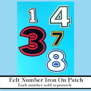 May include: Assorted felt number iron-on patches in various colors, including black, red, white, green, and yellow. The numbers 1, 3, 4, 7, and 8 are displayed against a light blue background. Text at the bottom reads "Felt Number Iron On Patch".