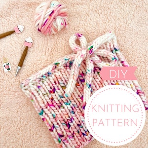 May include: DIY knitting pattern for a pink and white knit hat with a bow. The hat is made with chunky yarn and has a speckled pattern.