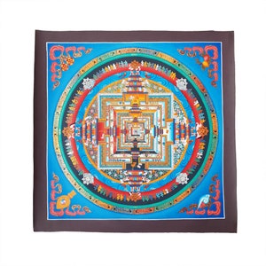 May include: A colourful mandala with intricate details and a square frame. The mandala is painted on a canvas with a dark brown border. The mandala features a central square with concentric squares and circles, surrounded by a ring of text and images.