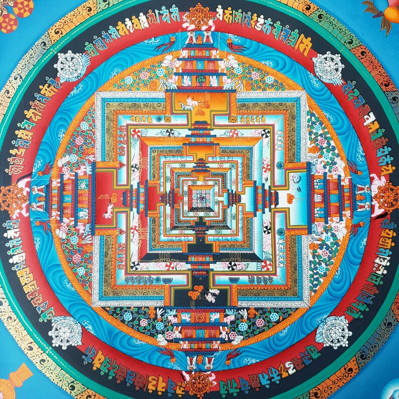 May include: A colourful mandala with a square design in the centre. The mandala is surrounded by a circle of text in a foreign language. The colours are vibrant and include blue, red, yellow, and green.