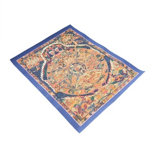 Pode incluir: Uma pintura de mandala budista tibetana colorida sobre um fundo azul. O mandala representa um desenho circular com detalhes intrincados e figuras.