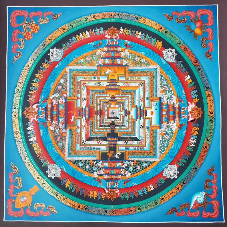 May include: A colourful mandala with intricate details and a square pattern in the centre. The mandala is surrounded by a circular border with text in a foreign language. The background is a vibrant blue.