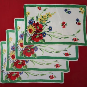 May include: Set of four white linen tea towels with a green border and a floral print featuring red, yellow, and blue flowers.