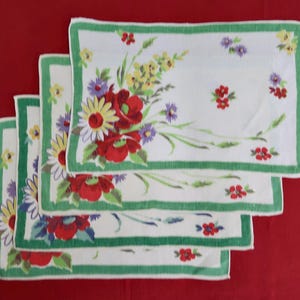 May include: Set of four vintage linen tea towels with a floral design featuring red, yellow, and purple flowers on a white background with green borders.