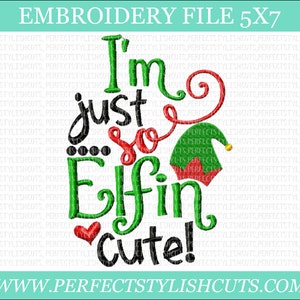 May include: Embroidered design featuring the text "I'm just so Elfin cute!" in green, red, and black lettering. A red and white elf hat with a yellow pom-pom is included in the design.