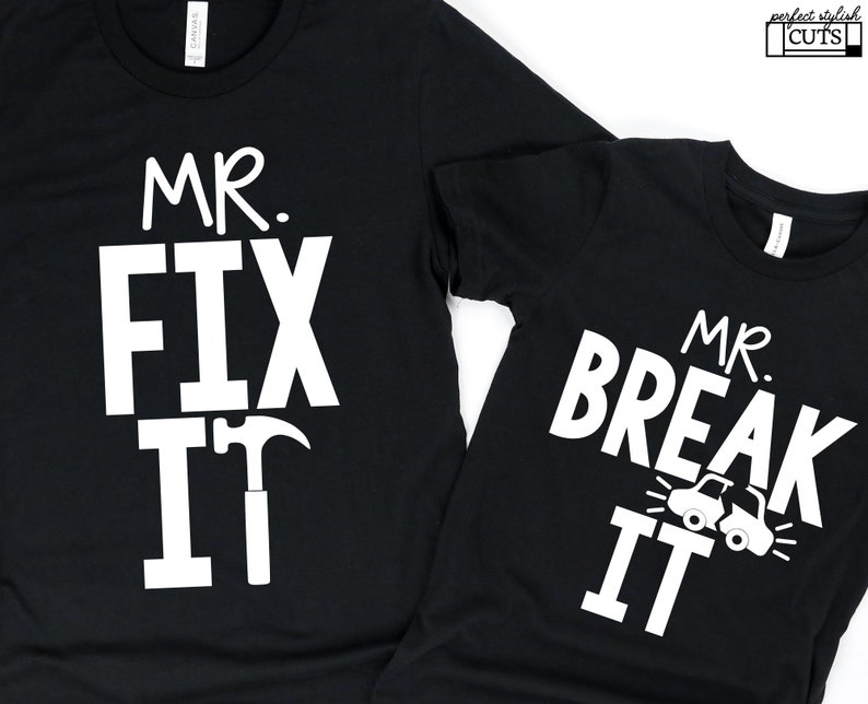 May include: Two black t-shirts with white text. The larger shirt says "Mr. Fix It" with a hammer and nail graphic. The smaller shirt says "Mr. Break It" with a car graphic.