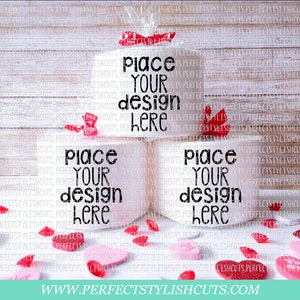 May include: Three white toilet paper rolls with the text "Place your design here" printed on each roll. The rolls are sitting on a white wooden surface with red and pink hearts scattered around them.