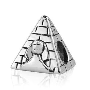 May include: Silver charm in the shape of a pyramid with a face carved into the side.