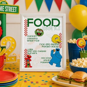 May include: A framed "Food Menu" sign with Sesame Street characters and food items like chicken, lasagna, and burgers. The scene includes balloons, popcorn, and sandwiches, creating a festive atmosphere.