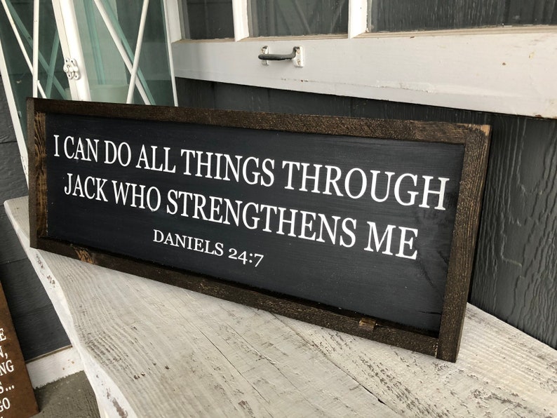 Op de afbeelding: Een zwart houten bord met witte tekst die luidt: "Ik kan alles doen door Hem die mij kracht geeft Dani&euml;l 24:7".
