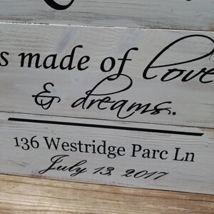May include: A white wooden sign with black lettering that reads "Home is made of love & dreams." The sign also includes the address "136 Westridge Parc Ln" and the date "July 13, 2017".