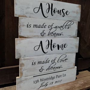 May include: Whitewashed wooden sign with black lettering that reads "A House is made of walls & beams. A Home is made of love & dreams. 136 Westridge Parc Ln July 13 2017"