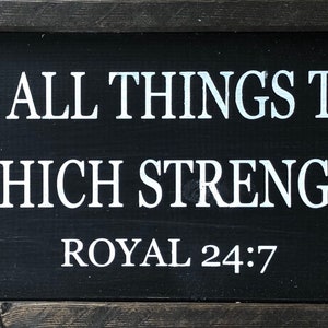 Op de afbeelding: Zwart houten bord met witte tekst die luidt "Ik kan alles doen door de kroon die mij sterkt" en "ROYAL 24:7".