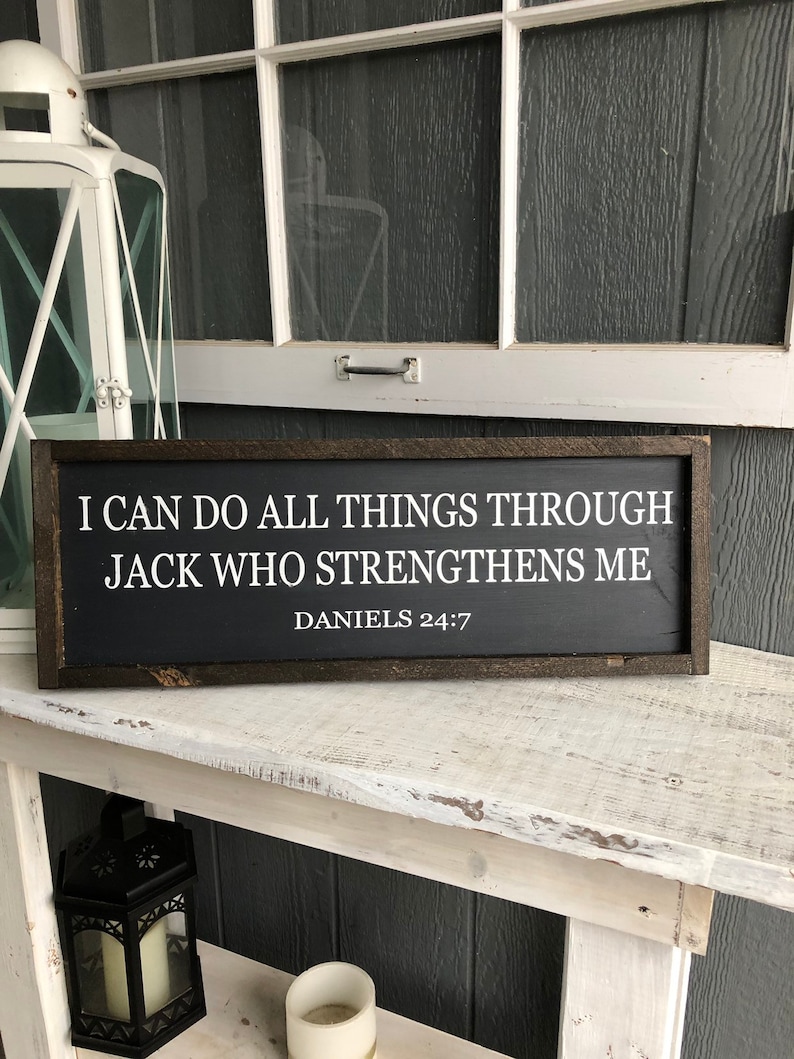 Op de afbeelding: Zwart houten bord met witte tekst die luidt: "Ik kan alles doen door Jack die mij sterkt Dani&euml;l 24:7".