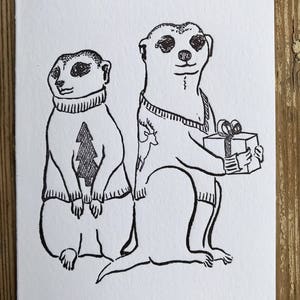Suricates dans la carte de chandails de vacances