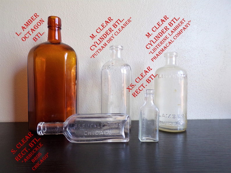 May include: Five glass bottles of various shapes and sizes. The bottles are clear and amber in color. The bottles have labels with text that includes "Putnam Dry Cleaner", "Listerine Lambert Pharmacal Company", "Arbuckle Bros Chicago", and "Chicago".