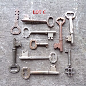 May include: A collection of ten antique keys, some with ornate designs, labeled "LOT C".