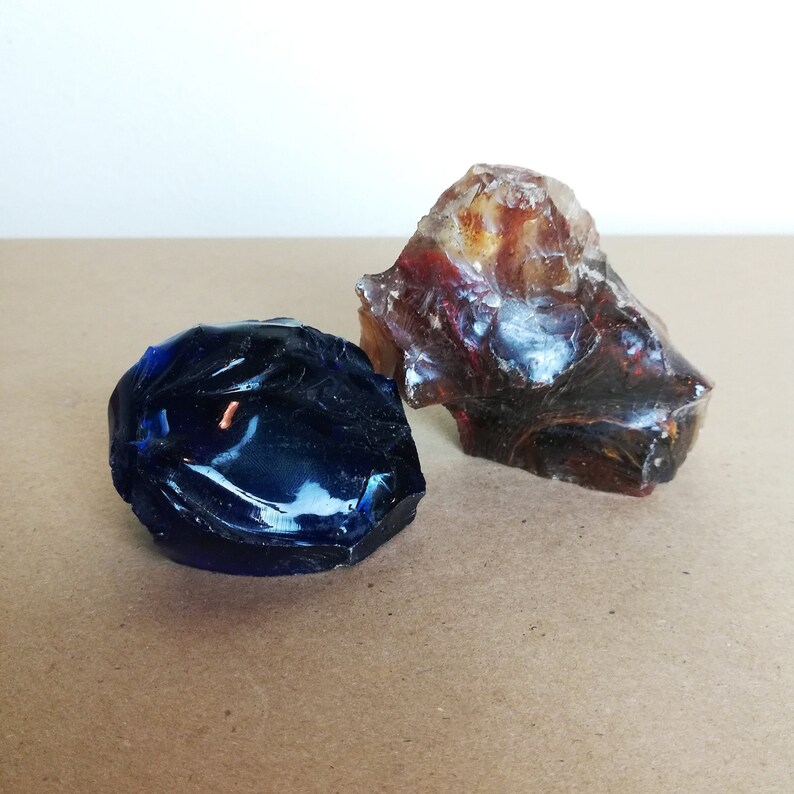 May include: Two pieces of slag glass, one blue and one brown with red and gold streaks.