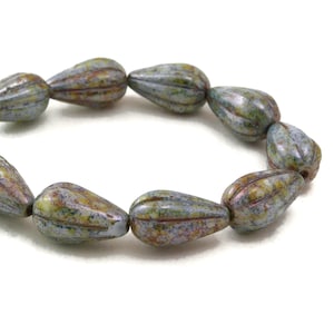 May include: A strand of light blue glass beads with brown and green marbling. The beads are shaped like teardrops and have a textured surface.