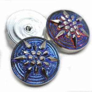 May include: Two iridescent glass buttons with a starburst design. One button is blue and the other is red, orange, and purple.