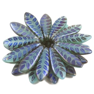 May include: A cluster of teal blue glass beads with a leaf pattern. The beads are iridescent and have a subtle shimmer.