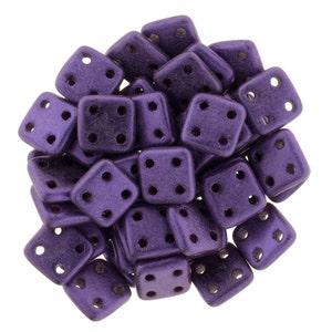 May include: A pile of purple square beads with four holes in each bead.