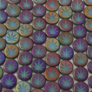 May include: A collection of round, iridescent glass beads with a leaf design. The beads are a mix of purple, blue, green, and gold.
