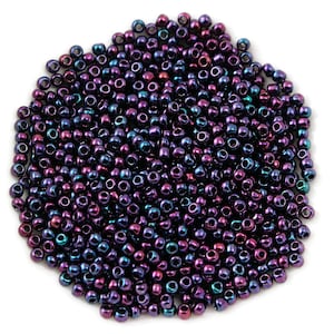 May include: A large pile of small, round, iridescent beads in shades of purple, blue, and green. The beads have a metallic finish and are perfect for jewelry making or crafting.