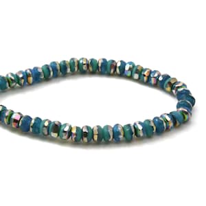 May include: A turquoise blue bracelet with iridescent glass beads. The beads have a faceted design and are strung on a clear elastic cord.