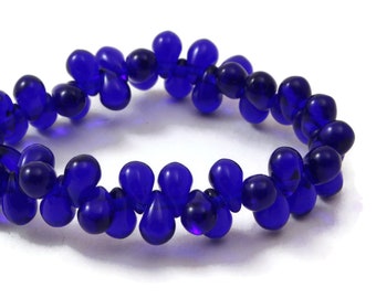May include: A bracelet made of blue glass beads in a teardrop shape.