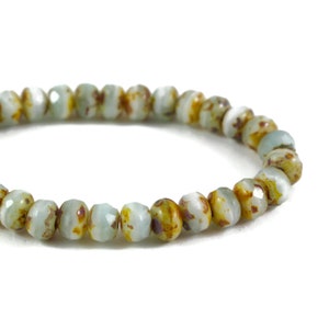 May include: A bracelet made of light blue and brown beads with a faceted finish.