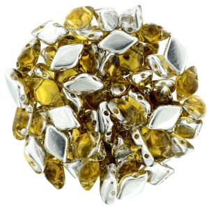 May include: A pile of small, faceted glass beads in a mix of amber and silver colors. The beads are shaped like elongated diamonds with two holes in each bead.