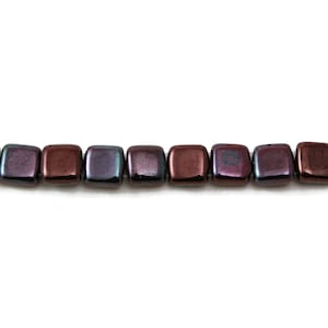 May include: A strand of square-shaped glass beads with a dark iridescent finish. The beads have a deep burgundy color with hints of purple and blue.