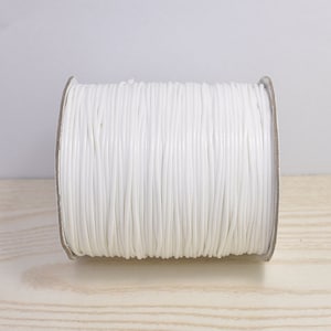 May include: A spool of white waxed cord, perfect for crafting and jewelry making.
