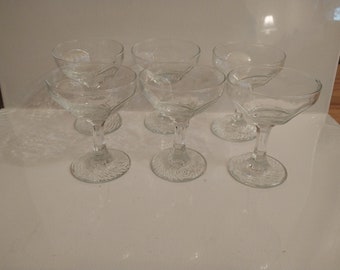 May include: Set of six clear glass stemmed cocktail glasses with a swirl design on the base.