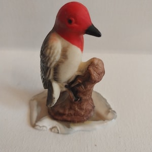 Red-Headed Bird On Thin Stone Base
