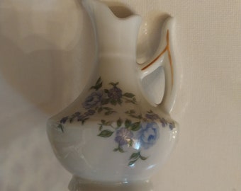 Jarrón con capullos de rosa y flores azules