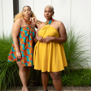 Black Women Wearing Yellow and Blue African Print Halter Neck Dresses from Besida