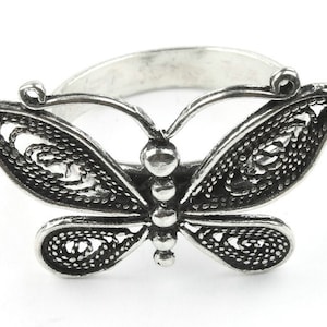 May include: Silver ring with a detailed butterfly design. The butterfly has intricate filigree wings and a beaded body.