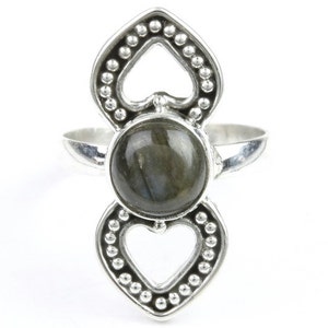 May include: A silver ring with a dark grey labradorite gemstone set in a heart-shaped design. The ring has a delicate, intricate design with small beads around the edges.